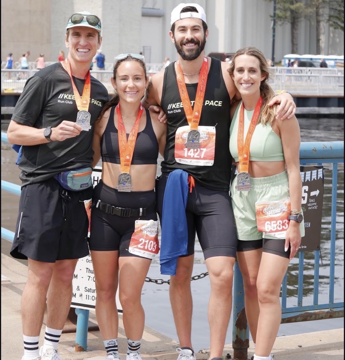 Four Keep The Pace Run Club coaches in club kit with finisher medals at Grandma's Marathon